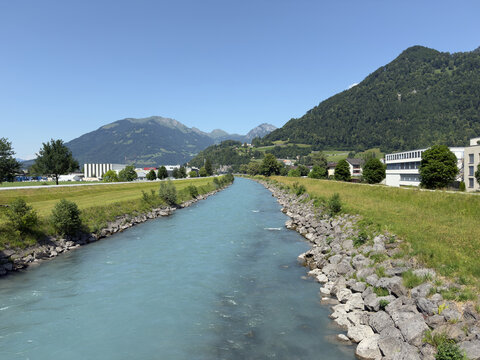Linth River Channel With Rocky Embankment Green Meadows and Alpine Mountain Views in Glarus Switzerland