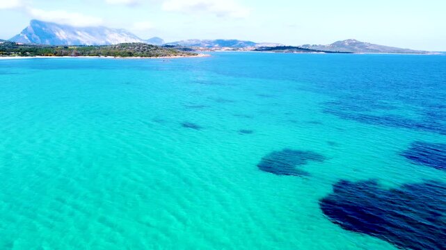 Aerial view of Cala Brandinchi in Sardinia showing turquoise shallow sea, white sandy beach and clear Mediterranean water with smooth coastal gradients