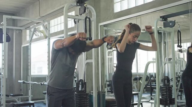 Couple working out together at the gym providing strength and support during their fitness training sessions