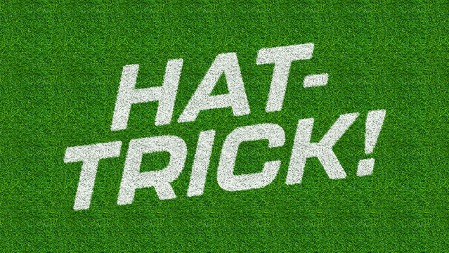 Text spelling Hat-Trick! is stenciled onto a vibrant green grassy surface.
