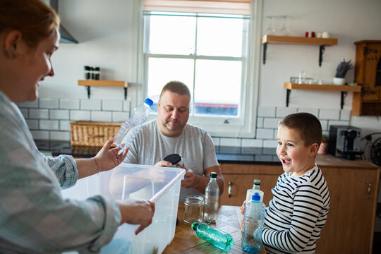 Parents and child sorting recycling in a home kitchen
