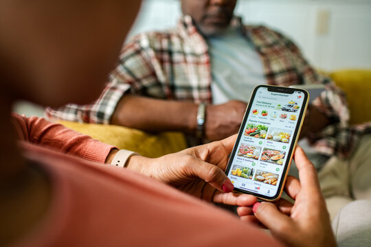 Couple using grocery delivery app at home