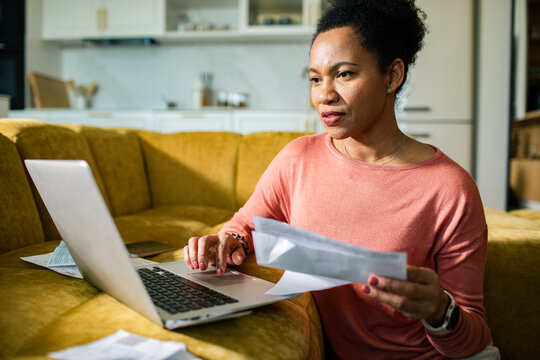 Woman paying bills online on laptop at home