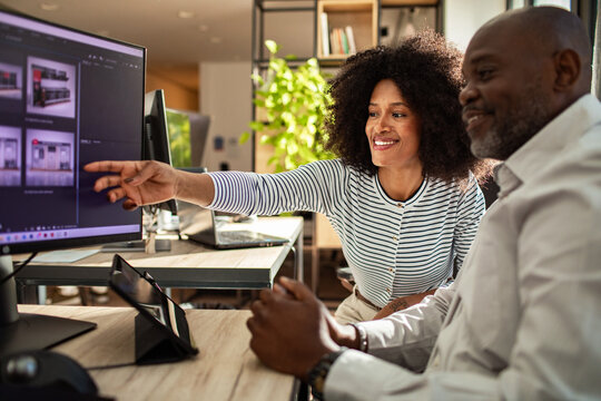 Two coworkers collaborating on computer in modern office