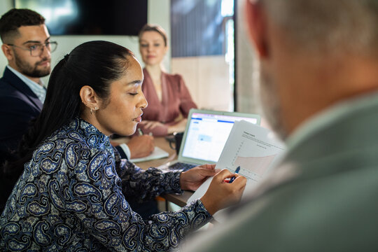 Diverse colleagues reviewing analytics in office meeting room