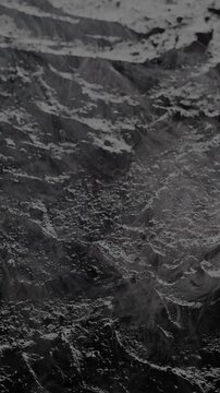 Rocky surface mist slow glide. Close-up of dark rocky texture with smooth flowing mist and smoke. Camera glides slowly revealing subtle movement and atmospheric depth.