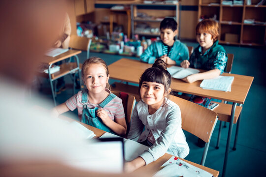 Elementary students listening to teacher in classroom