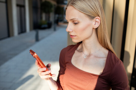 Young woman checking smartphone on city street