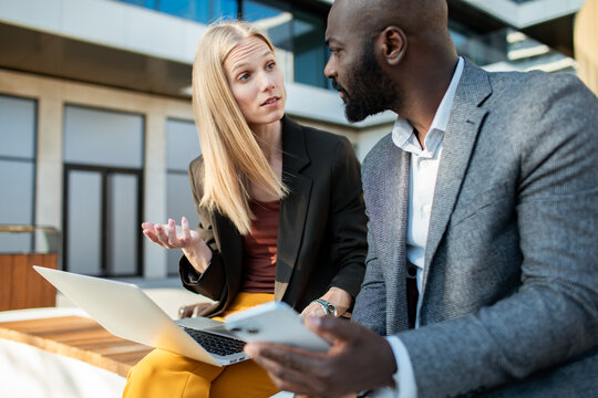 Coworkers discussing project on office patio