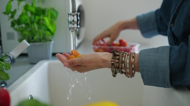Woman Washing Cherry Tomatoes Over The Sink