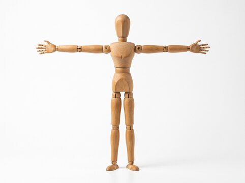 Wooden Artist Mannequin Standing with Arms Outstretched on a Plain White Background for Anatomy Study