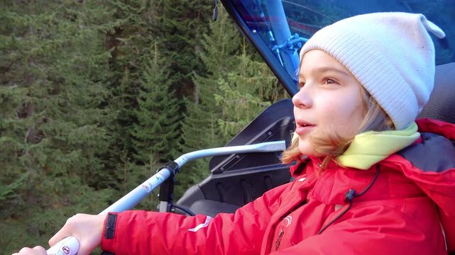 Girl in a red jacket rides in a funicular to the mountain. Lifts on Ski resort Rohace Express, Zuberec, Slovakia