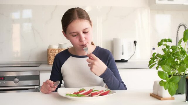 Little Girl Eating Fresh Caprese Salad In The Kitchen Enjoying A Healthy Breakfast