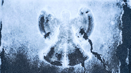 Naklejka premium Snow angel imprint on icy surface outdoors in winter