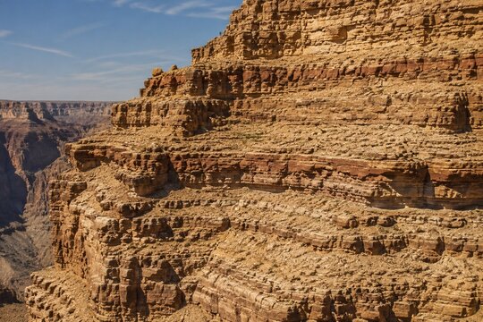 Stepped rock layers in a canyon wall, desert landscape.