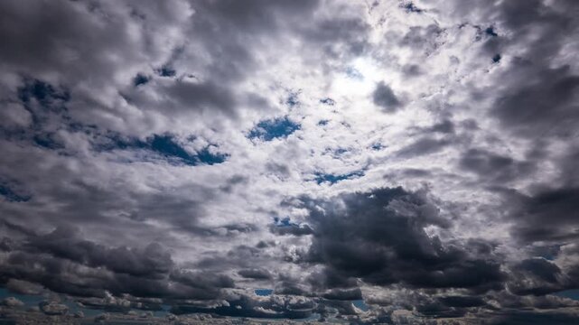 Dark storm clouds billow and shift rapidly across the sky as time accelerates during an approaching weather front. Concept of climate change, moody atmosphere, and the passage of time.