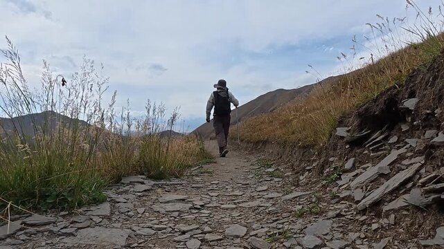 4k video of a hiker from behind walking on a rocky mountain trail in Juta valley, Georgia.