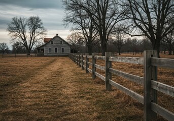 Fototapeta premium Classic aged wooden post and rail fence structure surrounding a beautiful rural property. It evokes feelings of rustic quiet isolation, landscape, peaceful, rails