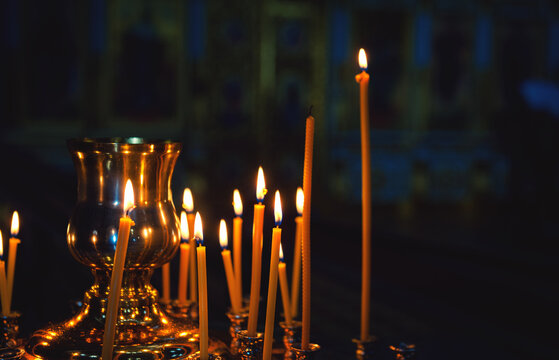 Soft lights surround the burning candle, creating a peaceful and spiritual atmosphere