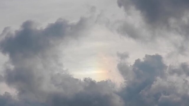 Natural grey sky with Parhelion, Sundog on Cirrostratus clouds and dark clouds cumulus in the evening. Topics: atmospheric optical phenomenon, cloudscape, meteorology, weather, climate, air space