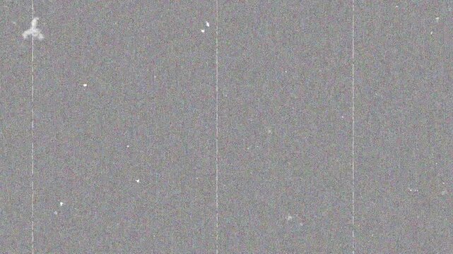 Grainy gray texture with white specks, film noise, and static distortion. Suitable for backgrounds, overlays, and vintage design projects.