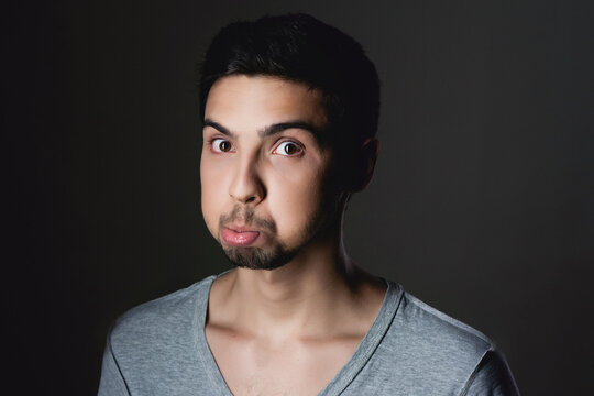 Young man holding breath with puffed cheeks