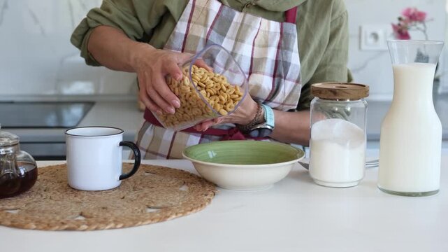 Woman Pouring Cereal At Home In The Kitchen Close-Up