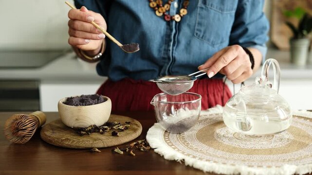 Woman Making Blue Matcha Tea And Sifting It Through A Strainer