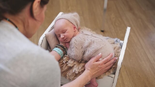Newborn Photographer Gently Stroking The Baby Backstage At A Photoshoot