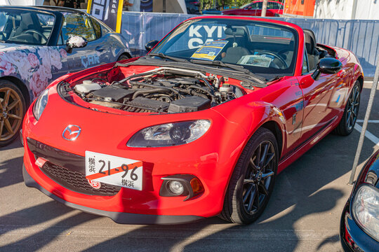 Vibrant red Mazda Miata parked on a bright, urban street Sleek design and glossy finish highlighted under natural light, with white license plate contrasting Dista - Kyiv, Ukraine - September 21, 2025