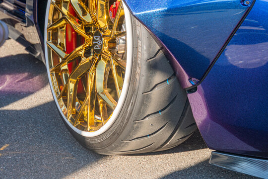 Close-up view of a purple Mazda Miata, side angle towards the rear wheels with gold F1-branded high-performance tires on carbon fiber bodywork, under soft natural li  Kyiv, Ukraine September 21, 2025