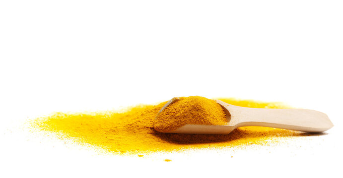 Turmeric scattered powder pile in wooden spoon isolated on white background, side view, clipping path