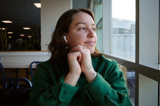 Woman sitting by window in a building during daytime