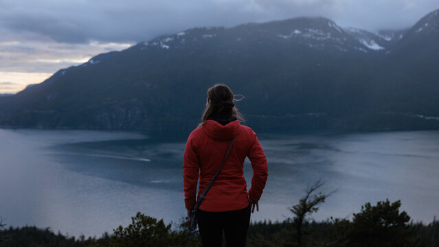 View from a mountain at sunset with a person standing alone