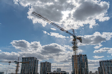 Fototapeta premium Bustling Urban Construction Site with Tower Crane and Modern Skyscrapers