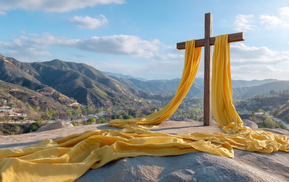 Tall Wooden Cross with Yellow Drapery Against Scenic Mountain View