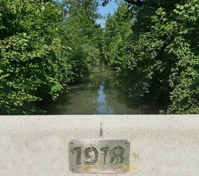 Garching-Hochbrueck, Germany -  Bridge over the Isar-Schleissheimer canal built in 1918 with an enchanting view of the water stream in the wild