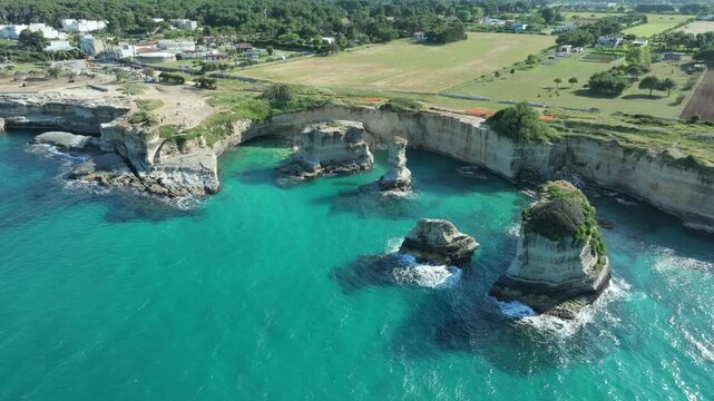 Aerial view of Faraglioni di Sant'Andrea sea stacks in Puglia, Puglia, Salento, Italy.