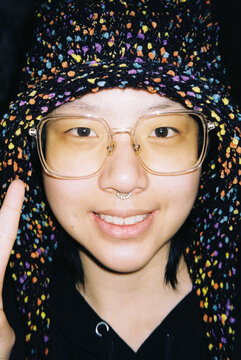 Smiling Person in a Colorful Crochet Hat and Clear Glasses