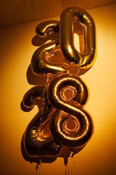 New Year 2028 Gold Balloons Against Yellow Wall