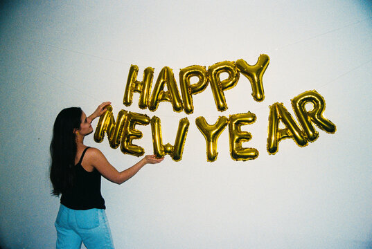 Woman arranging happy new year balloons film photo