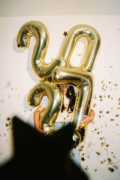 Smiling Woman with 2027 Balloons Celebrates New Year