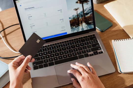 Woman booking Flights Online with Credit Card on Laptop
