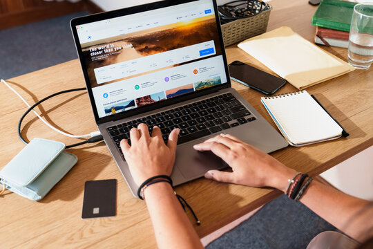 Person Searching Flights on Laptop with Credit Card on Desk