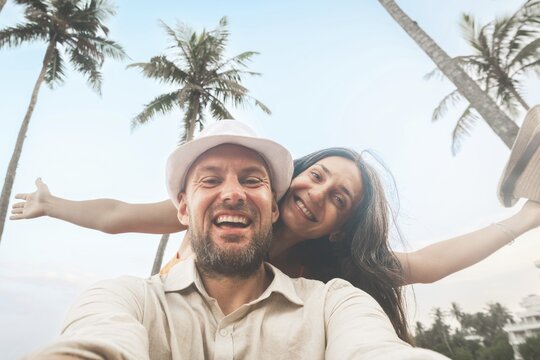 Young happy couple visit coconut island pose happy face taking holiday photo selfie in Sri lanka, Mirissa. People on holiday lifestyle concept