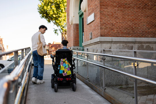 Navigating accessible ramp with friend providing support
