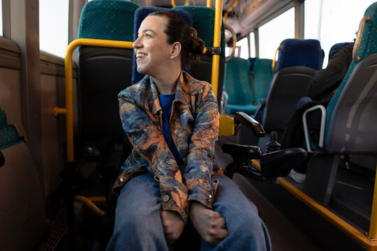 Woman smiling riding public transport enjoying accessibility