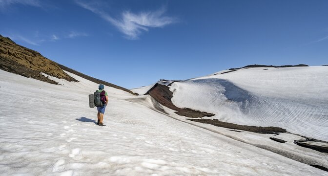 Hikers on the Fimmv&ouml;r&eth;uh&aacute;ls trail on a snowfield, barren volcanic landscape, lava sand and snowfields, &THORN;&oacute;rsm&ouml;rk Nature Reserve, Su&eth;urland, Iceland