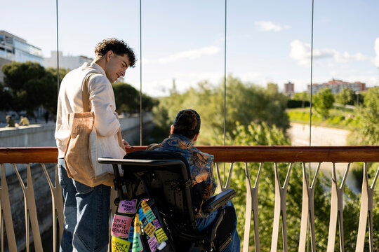 Friends sharing moment outdoors, discussing urban view