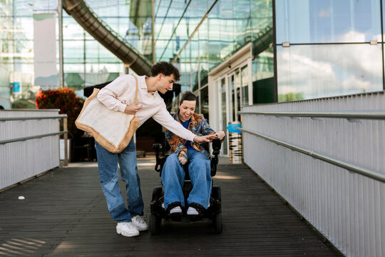 Young man connecting with woman in electric wheelchair